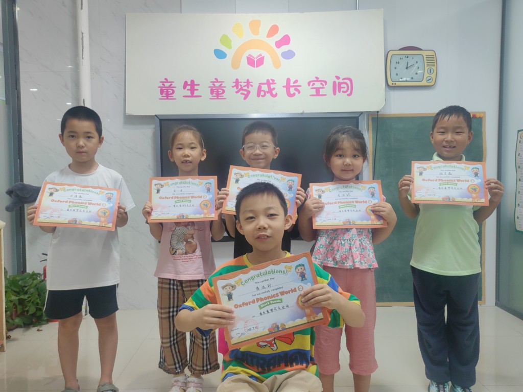 童生童梦成长空间学员手持剑桥/牛津英语结业证书合影